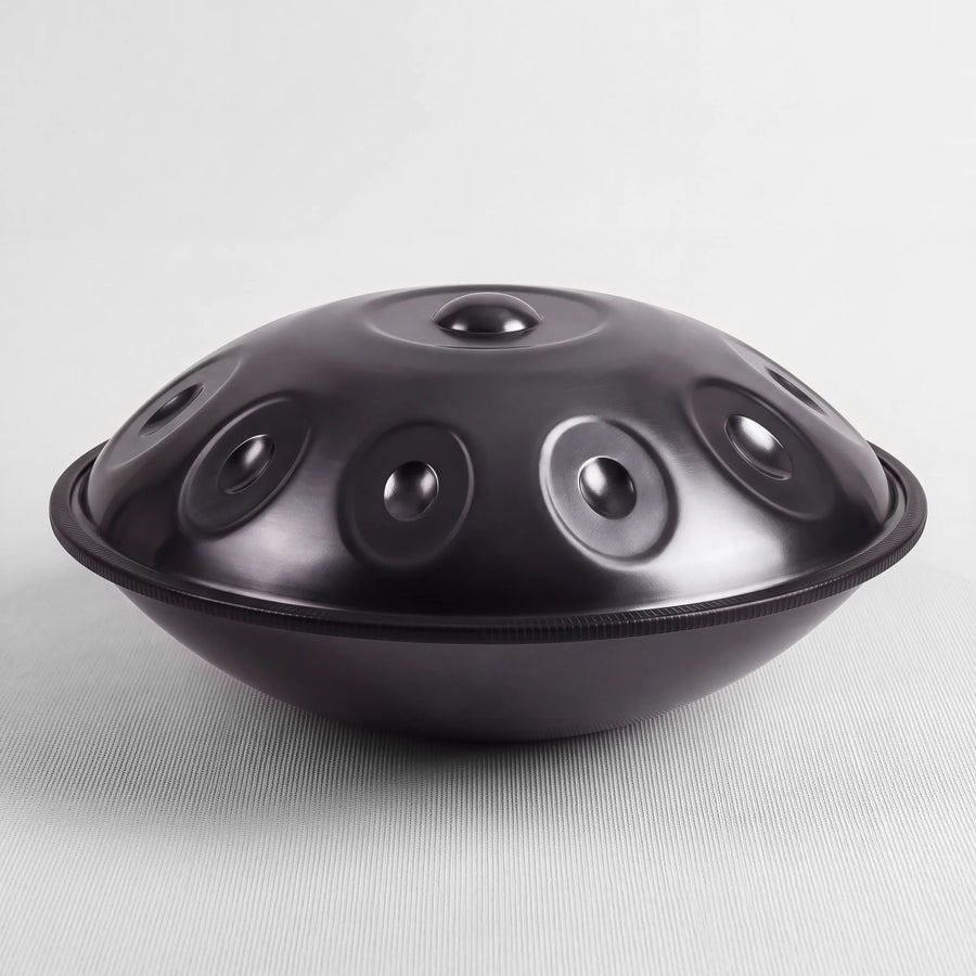 Sonant D Kurd handpan with 10 notes in a black finish, viewed from the side with its rim and rounded bottom shell — 8