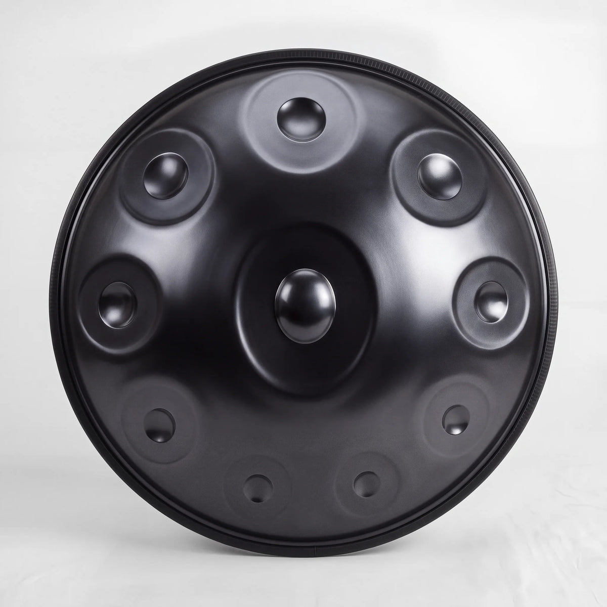 Front view of a Sonant D Kurd handpan with 10 notes in a black finish, showing its central dome and 9 tone fields