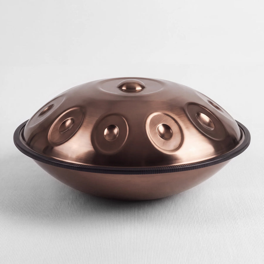 Sonant D Kurd handpan with 10 notes in a bronze finish, viewed from the side with its rim and rounded bottom shell — 14