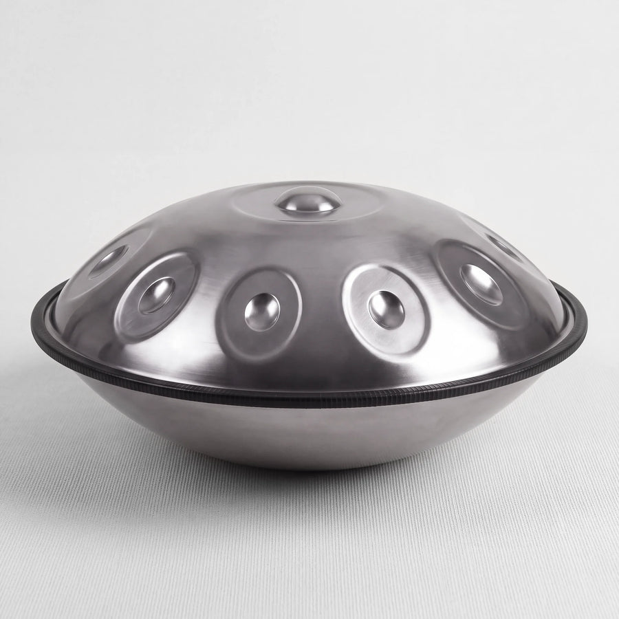 Sonant D Kurd handpan with 10 notes in a silver finish, viewed from the side with its rim and rounded bottom shell — 2