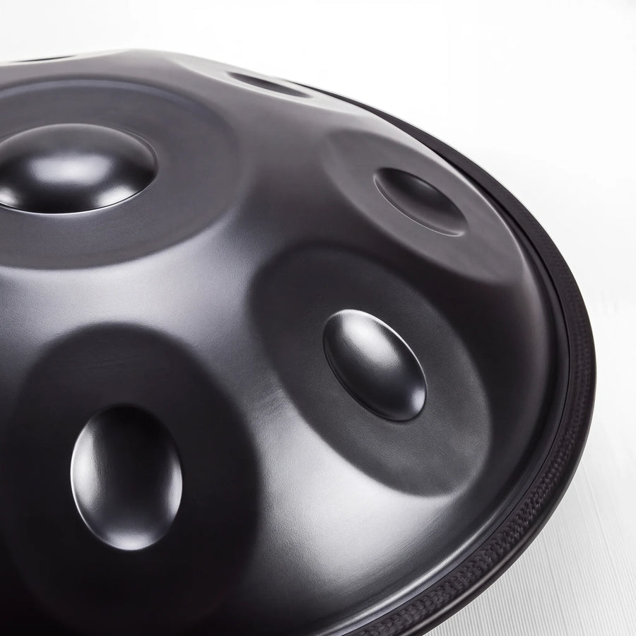 Close view of a Sonant D Kurd handpan with 12 notes in a black finish, showing its tone fields and rim — 15