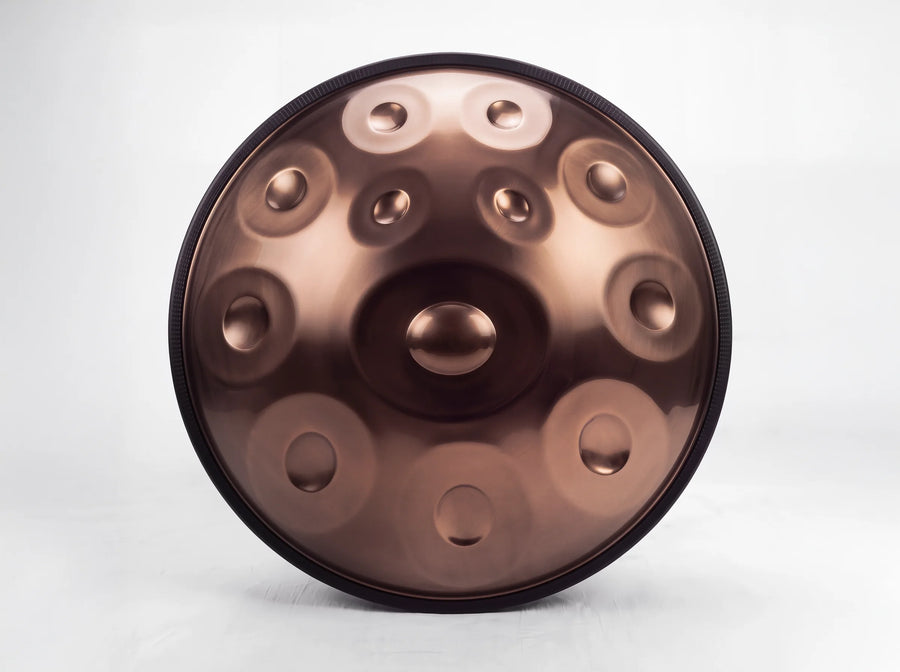 Front view of a steel handpan with 12 notes and a bronze finish, showing its central dome and 11 surrounding notes