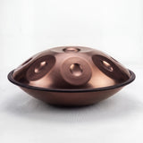 Sonant D Kurd handpan with 12 notes in a bronze finish, viewed from the side with its rim and rounded bottom shell — 2