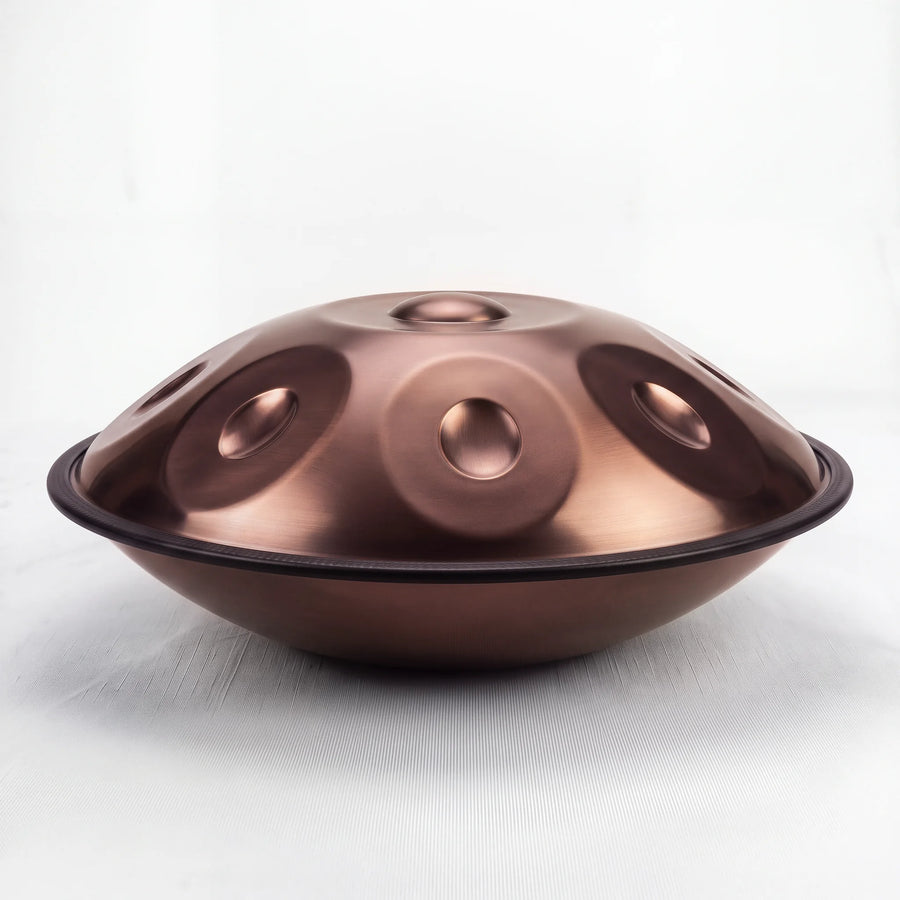 Sonant D Kurd handpan with 12 notes in a bronze finish, viewed from the side with its rim and rounded bottom shell — 2