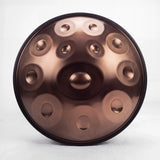Front view of a Sonant D Kurd handpan with 12 notes in a bronze finish, showing its central dome and 11 tone fields — 1