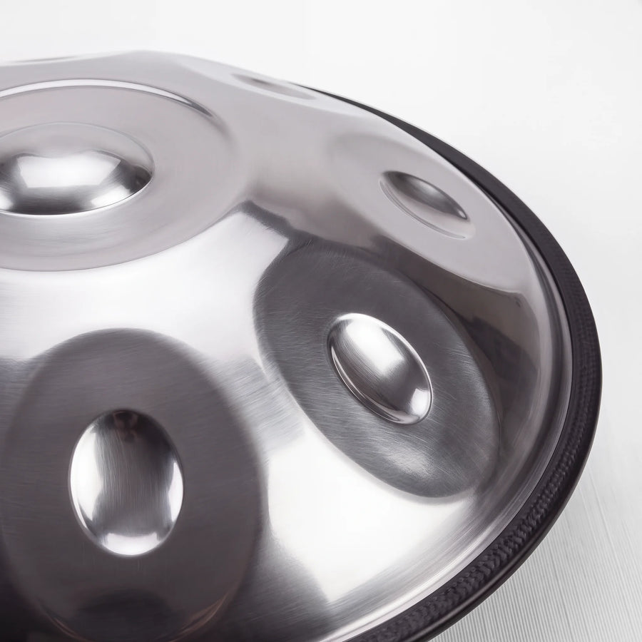 Close view of a Sonant D Kurd handpan with 12 notes in a silver finish, showing its tone fields and rim — 9