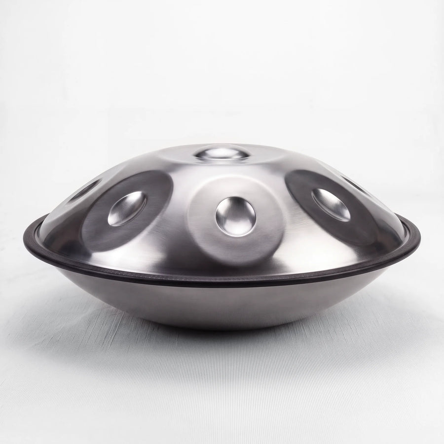 Sonant D Kurd handpan with 12 notes in a silver finish, viewed from the side with its rim and rounded bottom shell — 8