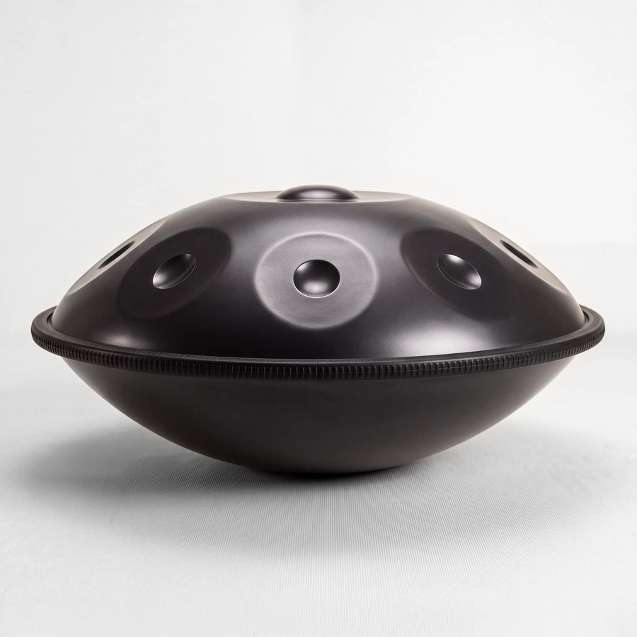 Sonant D Kurd handpan with 9 notes in a black finish, viewed from the side with its rim and rounded bottom shell — 2