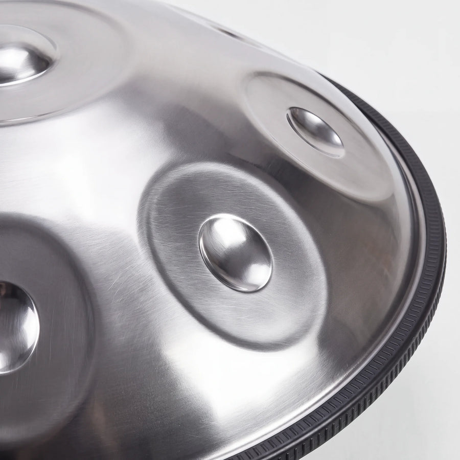 Close view of a Sonant D Kurd handpan with 9 notes in a silver finish, showing its tone fields and rim — 9