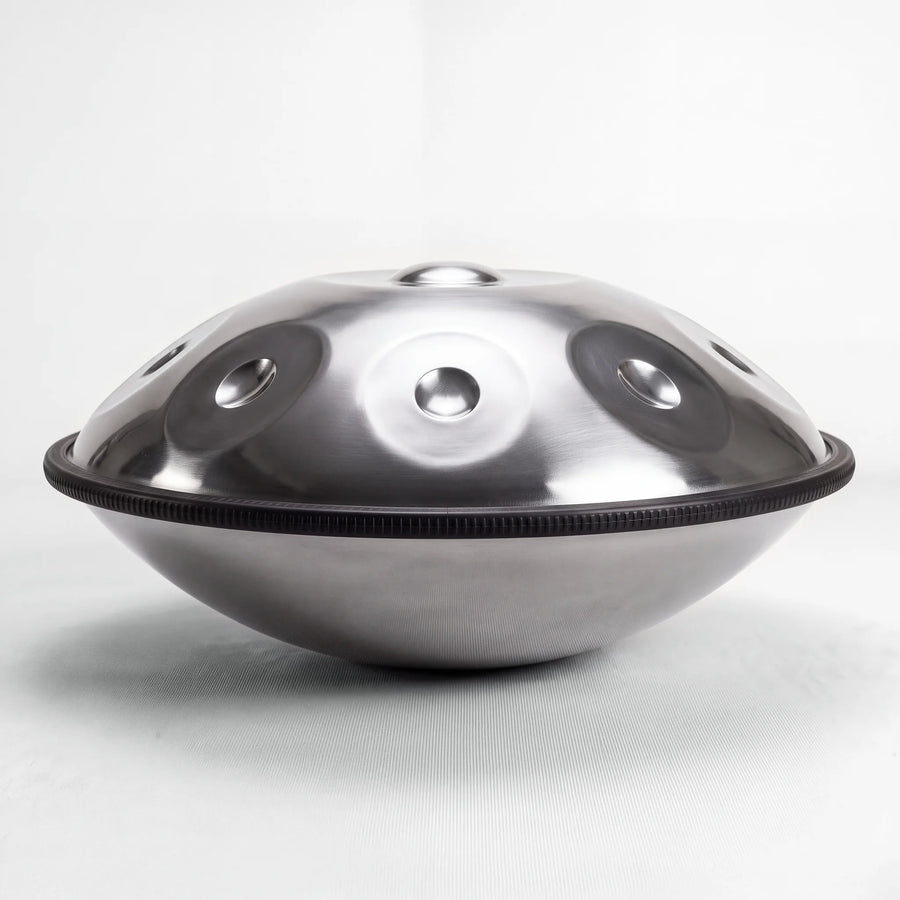 Sonant D Kurd handpan with 9 notes in a silver finish, viewed from the side with its rim and rounded bottom shell — 8